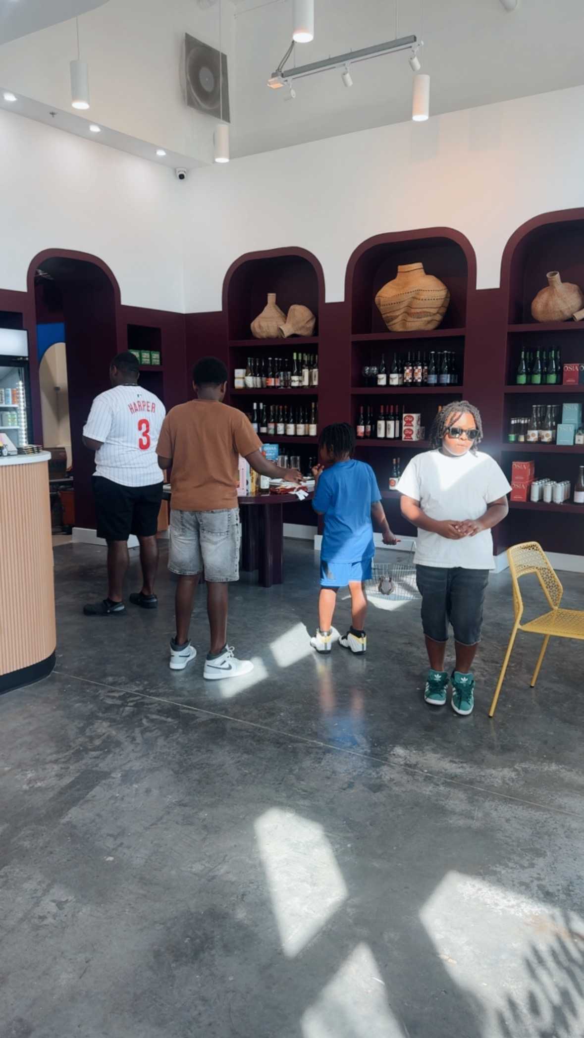 Family exploring the curved shelves inside Nelly's Grocery and Wine.